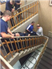 Group Carrying a Dummy down the Stairs
